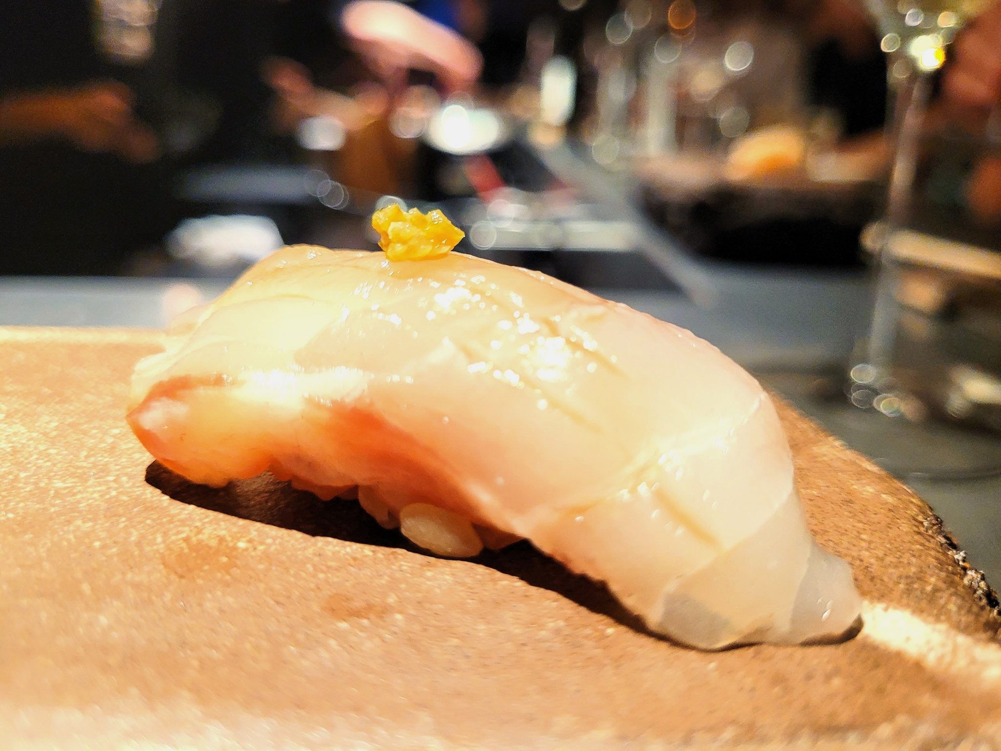Nigiri de lubina madurada, pasta de yuzu y chiles verdes Bakko